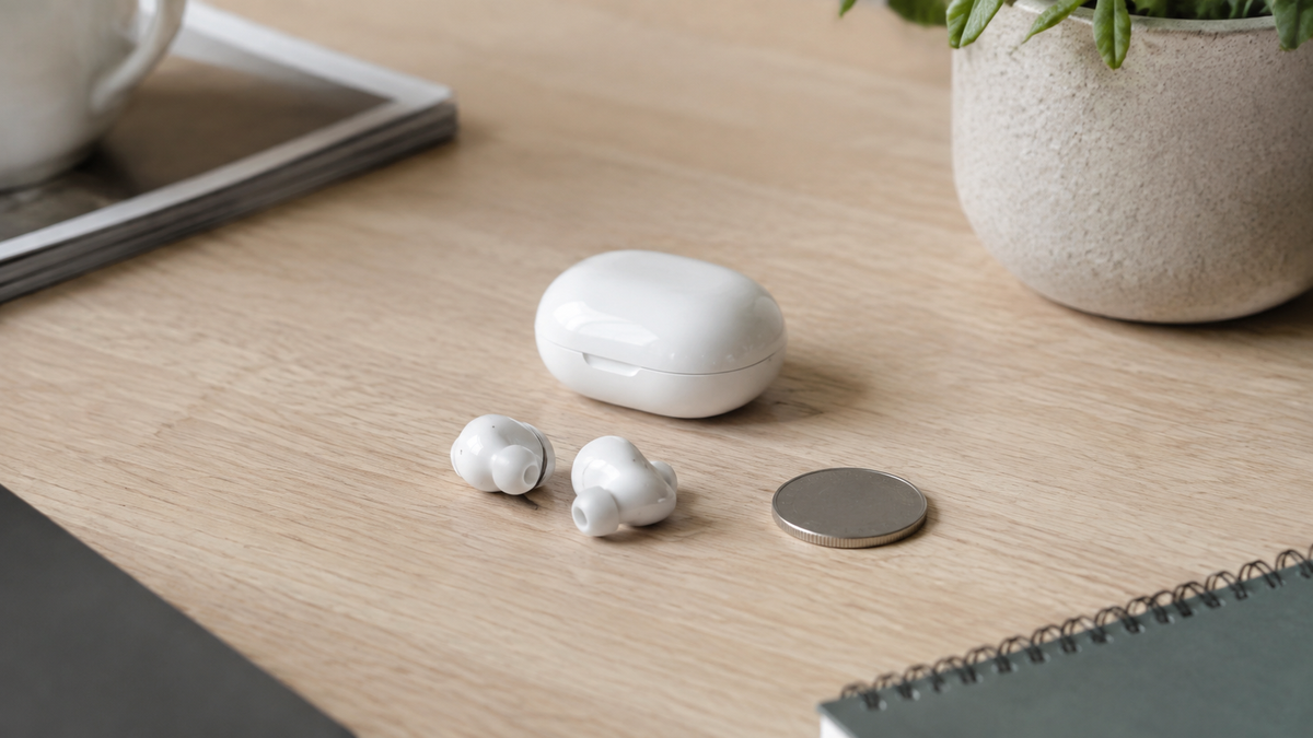 Compact unbranded Bluetooth earbuds and charging case on a desk