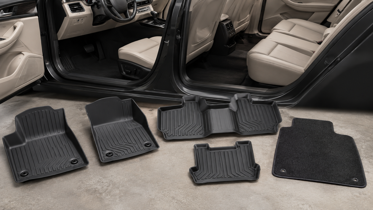 Set of black all-weather and carpet car mats beside a clean vehicle interior