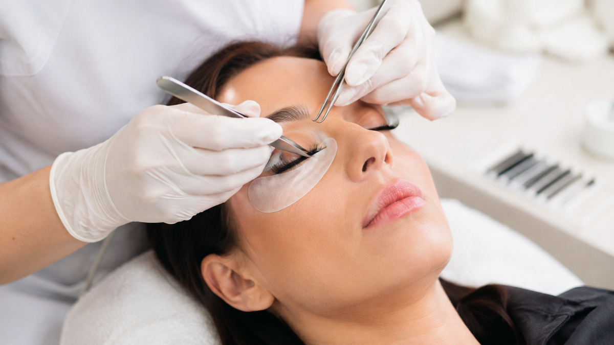 Professional hygienic eyelash extension application in a bright beauty studio