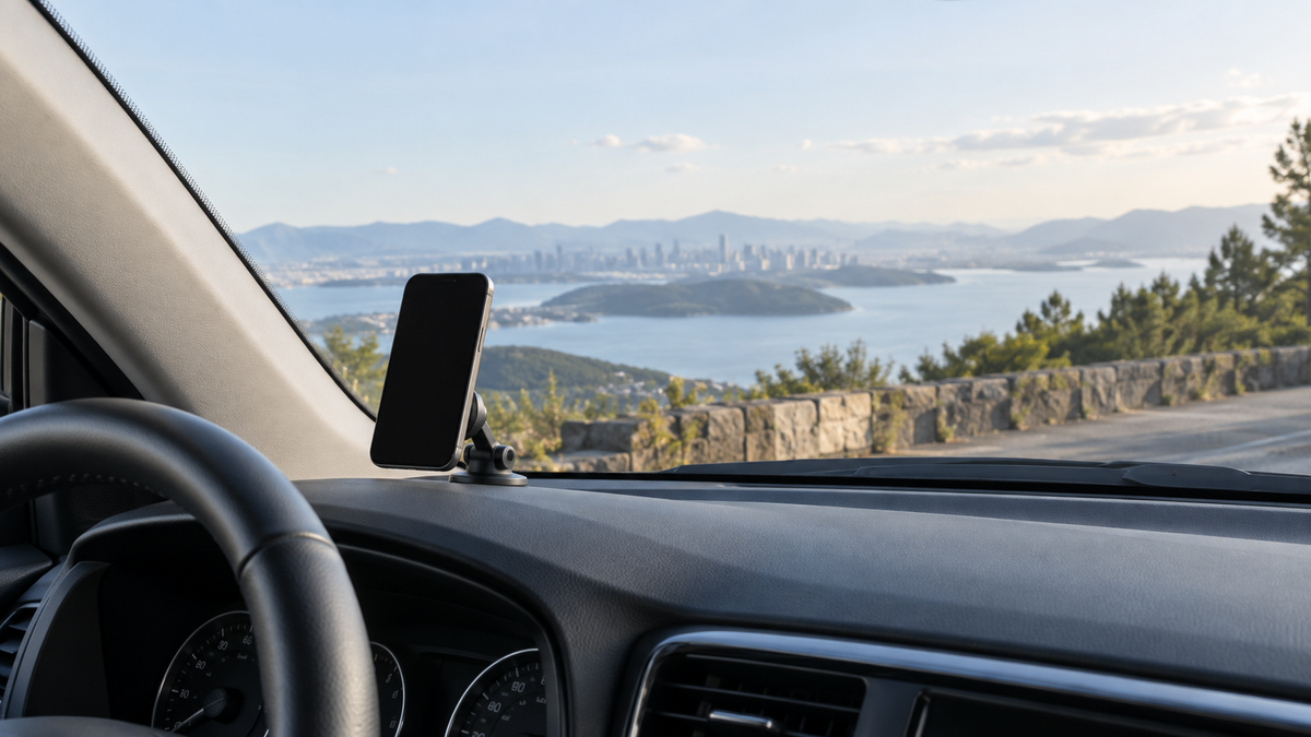 Unbranded magnetic phone holder attached low on a parked car windshield with clear view