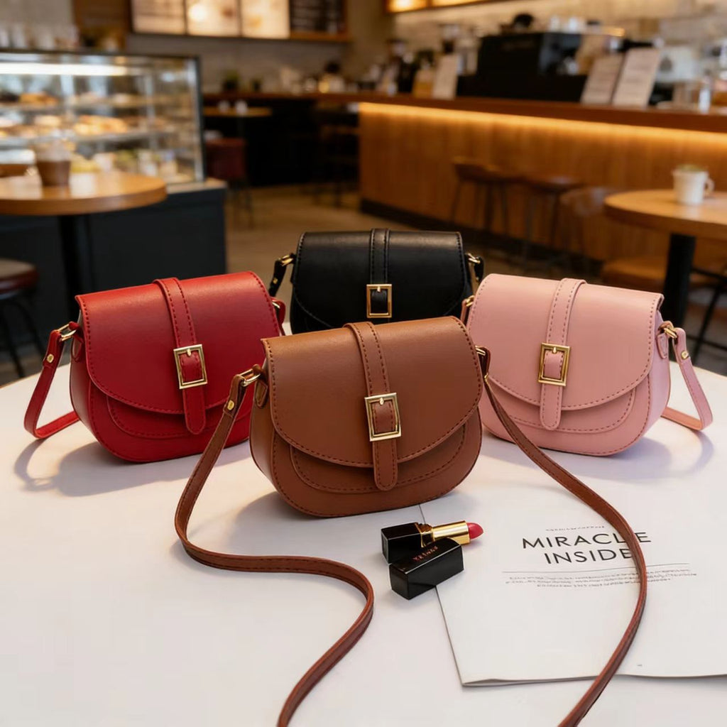 Simple metal-buckle flap crossbody saddle bag with an adjustable shoulder strap.