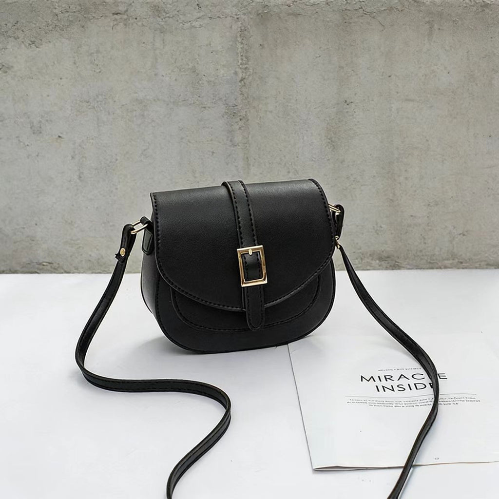 Simple metal-buckle flap crossbody saddle bag with an adjustable shoulder strap.